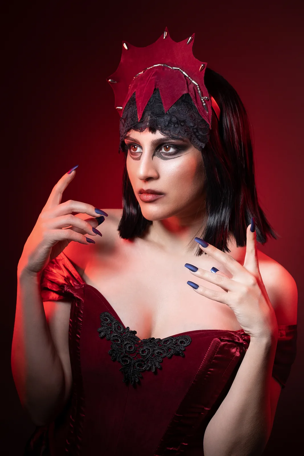 Portrait in red with a crown and corset, red light from the side