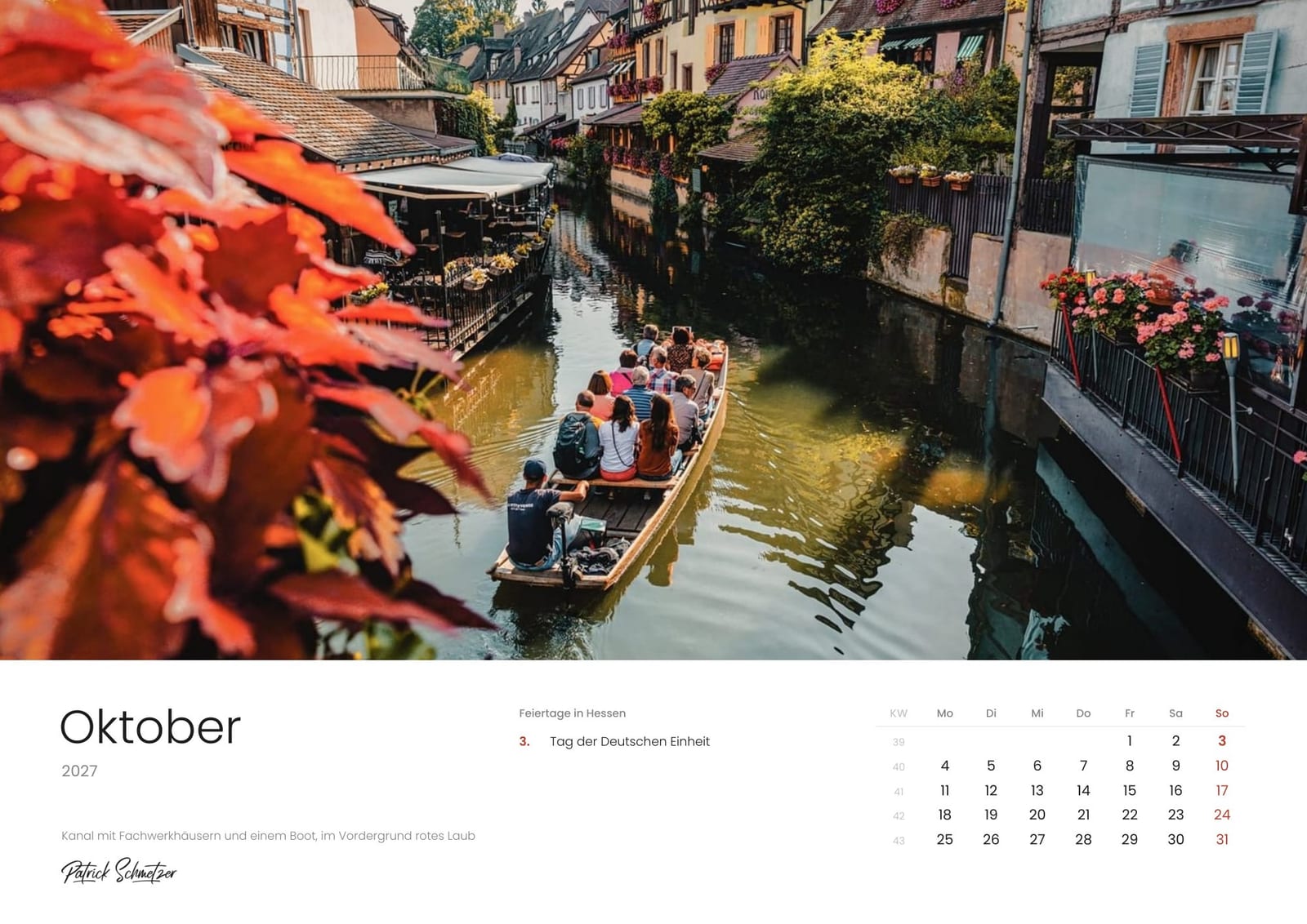 Calendar page October 2027: A canal with half-timbered houses and a boat, red leaves in the foreground