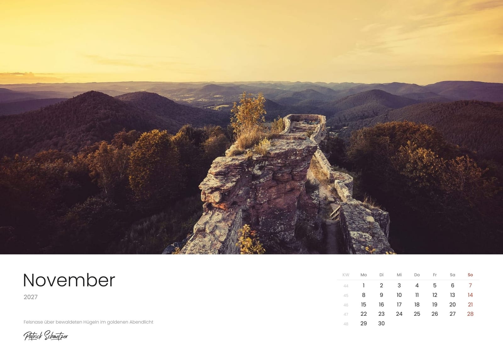 Calendar page November 2027: A rock outcrop above wooded hills in golden evening light