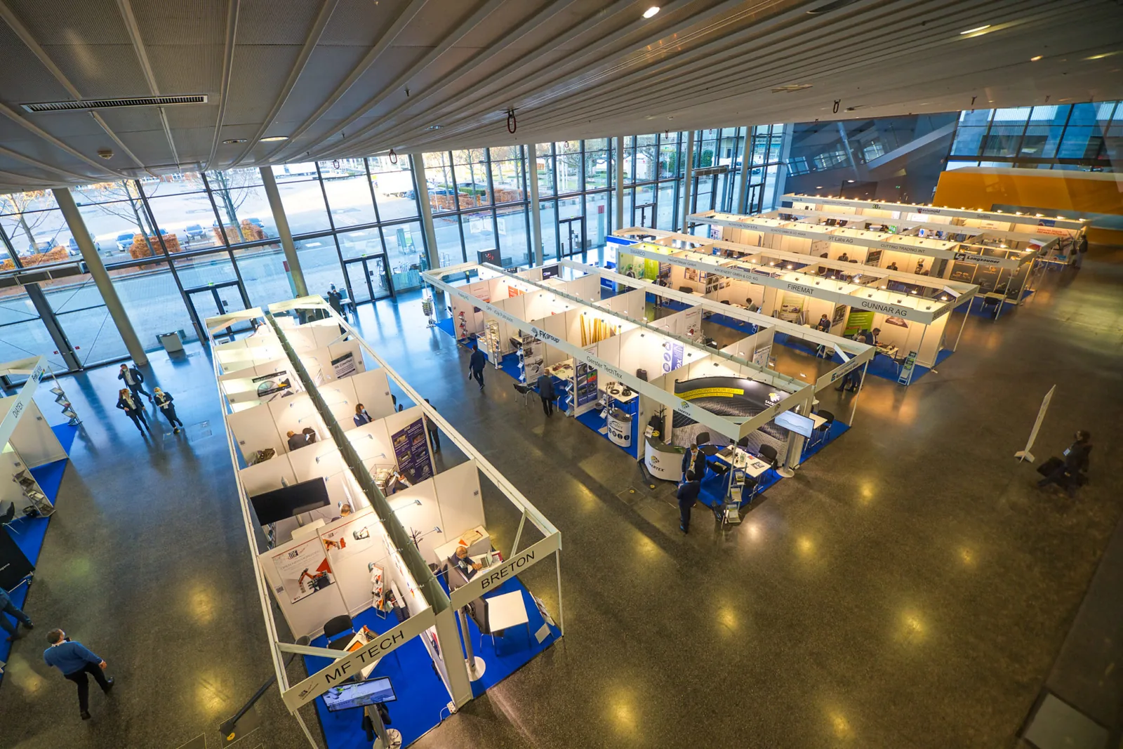 Blick von oben in eine Messehalle mit weißen Ausstellungsständen beim JEC Forum DACH in Frankfurt