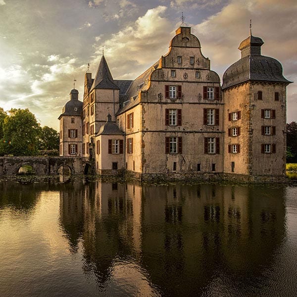 Wasserschloss, das sich in seinem Graben spiegelt