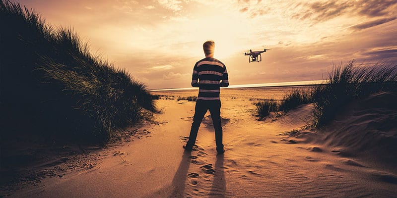 Drohne über Stranddünen bei Sonnenuntergang
