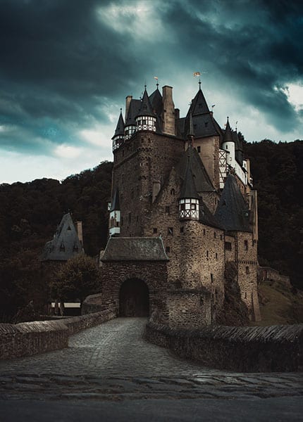 Burg über bewaldeten Hängen