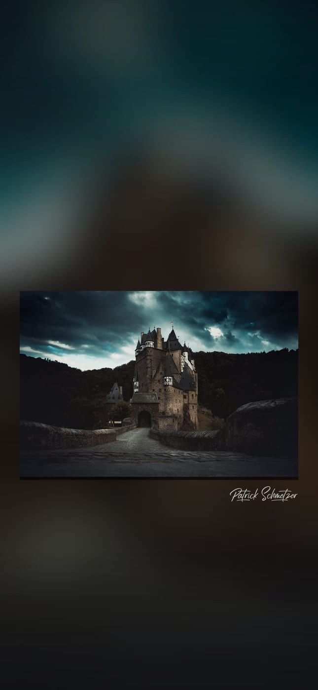 Burg im Wald unter dunklen Gewitterwolken