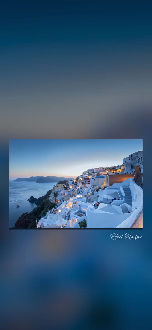 Weiße Häuser an der Steilküste von Santorini in der Abenddämmerung